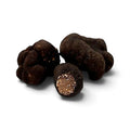 Truffes noires d'hiver fraîches Tuber brumale, de catégorie A, dont un spécimen coupé révélant l'intérieur sombre naturellement marbré